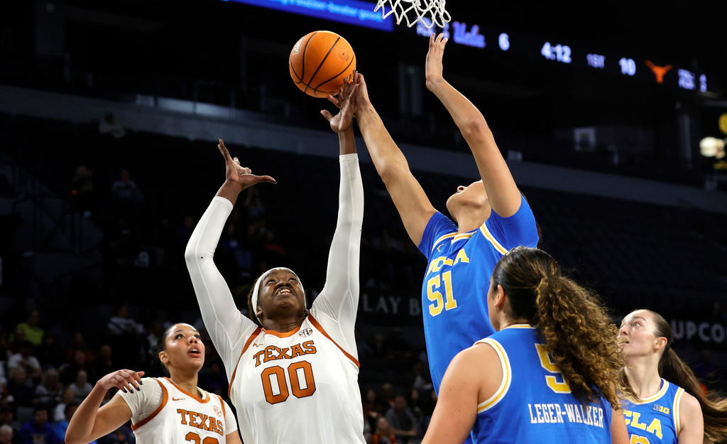 Texas center Kyla Oldacre (00) and UCLA center Lauren Betts (51) go after a rebound during the first half of an NCAA college basketball game in the Players Era tournament Wednesday, Nov. 26, 2025, in Las Vegas. (AP Photo/Steve Marcus)