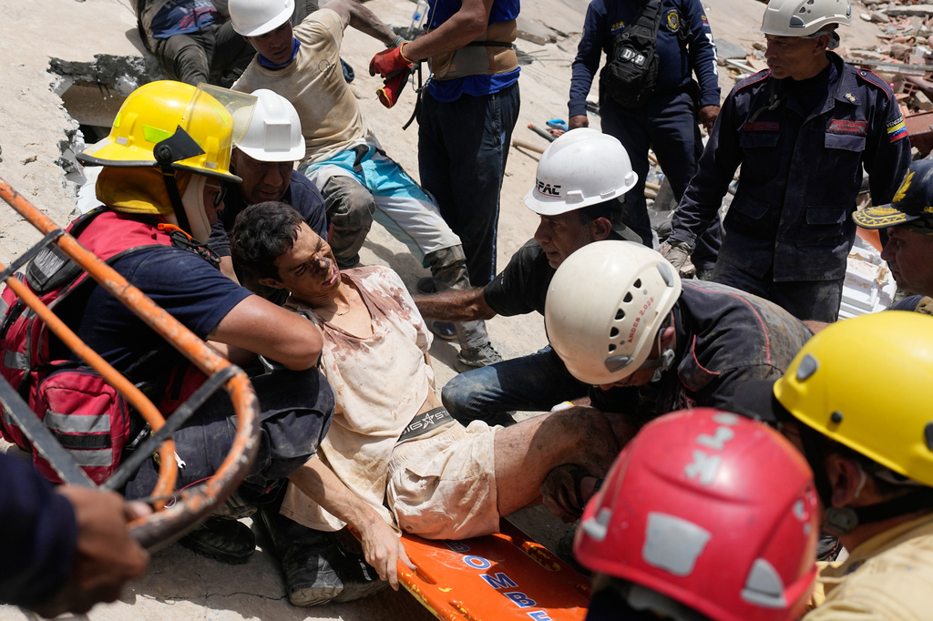 Rescue workers place Daniel Cordero on a stretcher after pulling him from the rubble two days after an earthquake struck Catia la Mar, Venezuela, Friday, June 26, 2026. (AP Photo/Fernando Vergara)