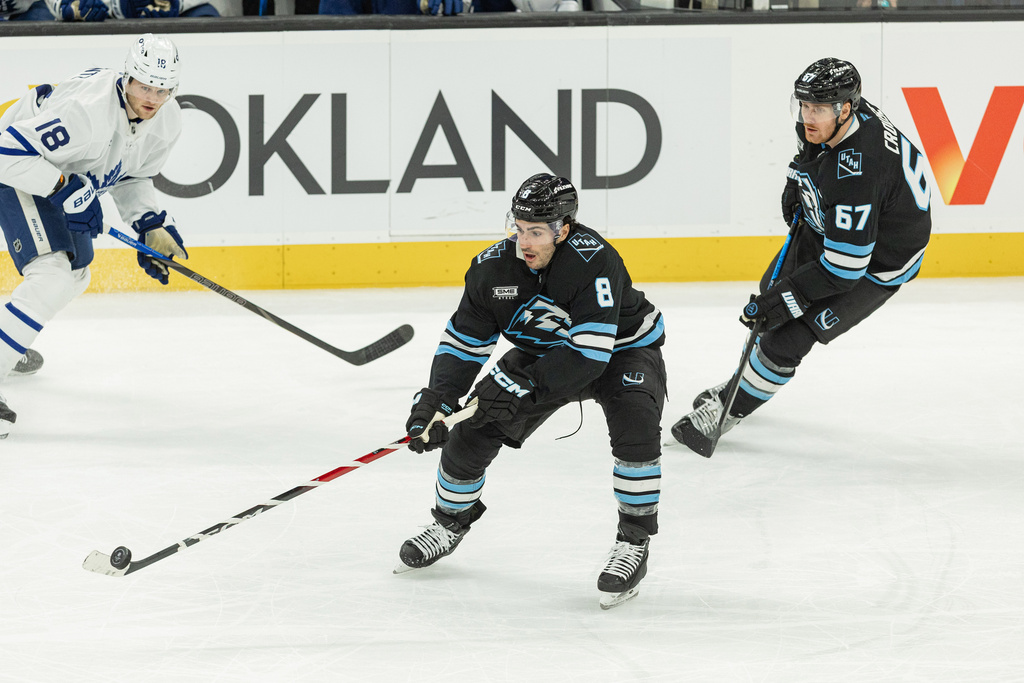 Utah Mammoth center Nick Schmaltz (8) moves the puck on the ice against Toronto Maple Leafs center Steven Lorentz (18) during the third period of an NHL hockey game Tuesday, Jan. 13, 2026, in Salt Lake City. (AP Photo/Melissa Majchrzak)
