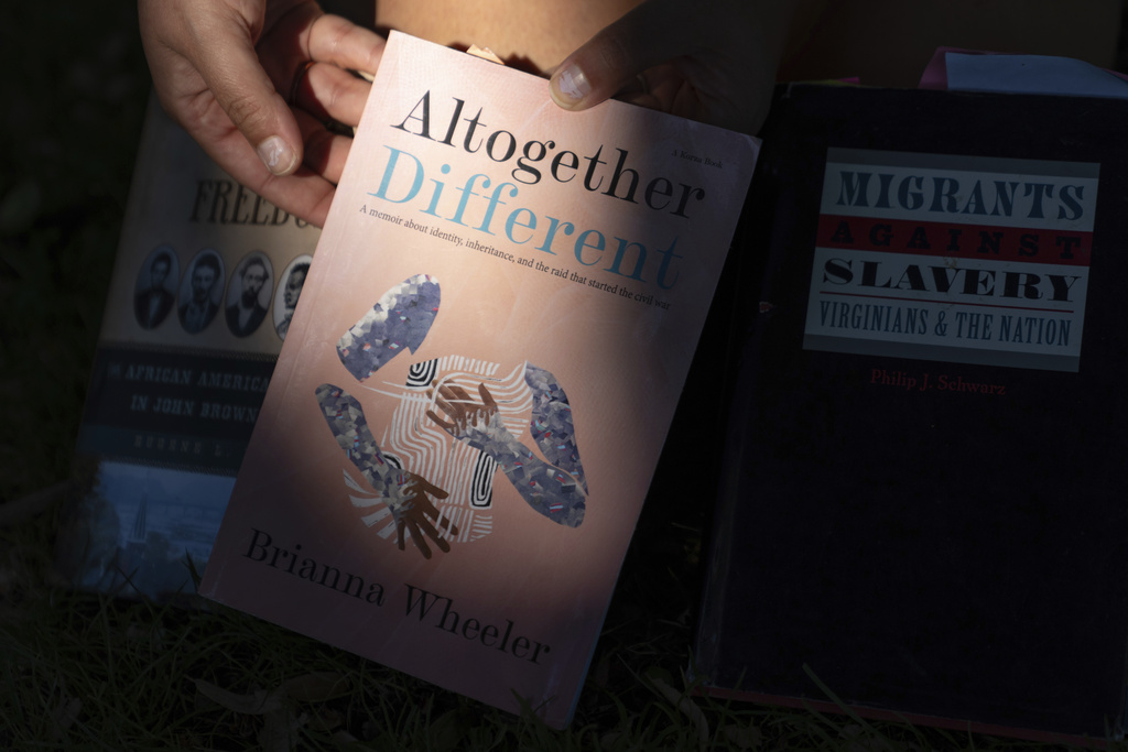 Brianna Wheeler holds her book "Altogether Different" as she poses for photos at Peninsula Park, Monday, Sept. 22, 2025, in Portland, Ore. (AP Photo/Jenny Kane)