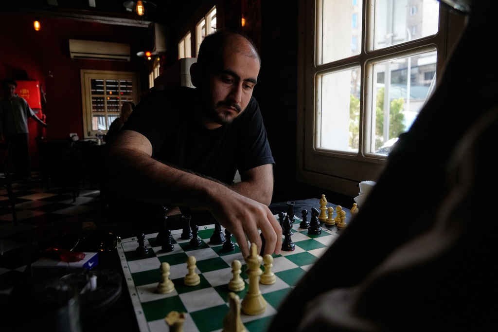 Men play chess as they spend an afternoon at a cafe in downtown Tehran, Iran, Monday, Aug. 17, 2026. (AP Photo/Vahid Salemi)