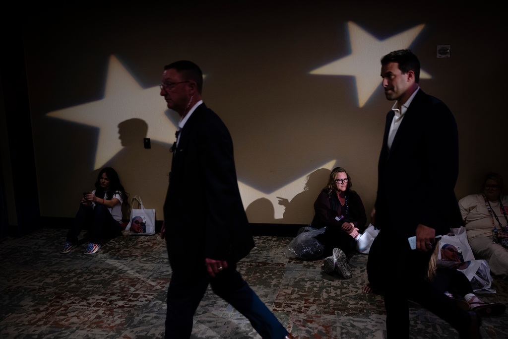 Attendees sit on the floor during Turning Point USA's AmericaFest 2025, Thursday, Dec. 18, 2025, in Phoenix. (AP Photo/Jon Cherry)
