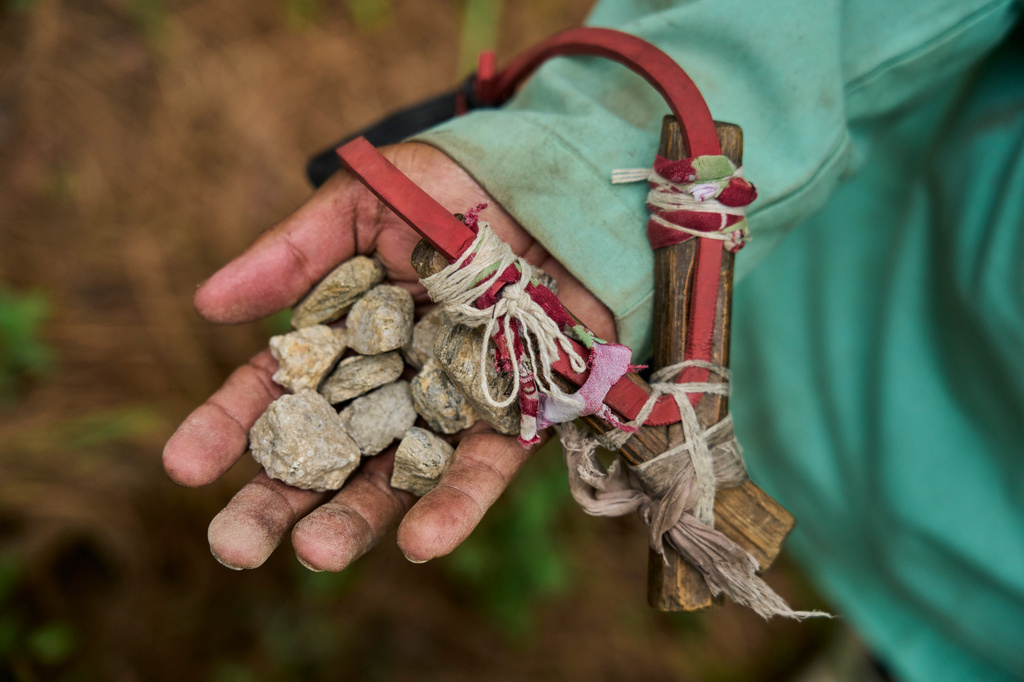 A farmer shows the slingshot and stones he uses to chase monkeys away from nearby farmland in Dharamghar, Dolakha district, about 86 kilometers (53 miles) east of Kathmandu, Nepal, Friday, July 24, 2026. (AP Photo/Niranjan Shrestha)