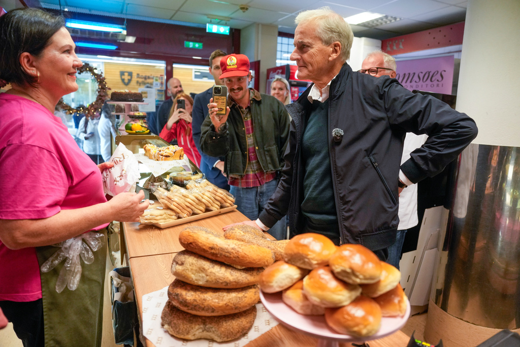 Jonas Gahr Store, right, chairman of Norway's Ap party buys food during an election tour in Stavanger, Norway, Wednesday, Sept. 3, 2025. (Stian Lysberg Solum/NTB Scanpix via AP)