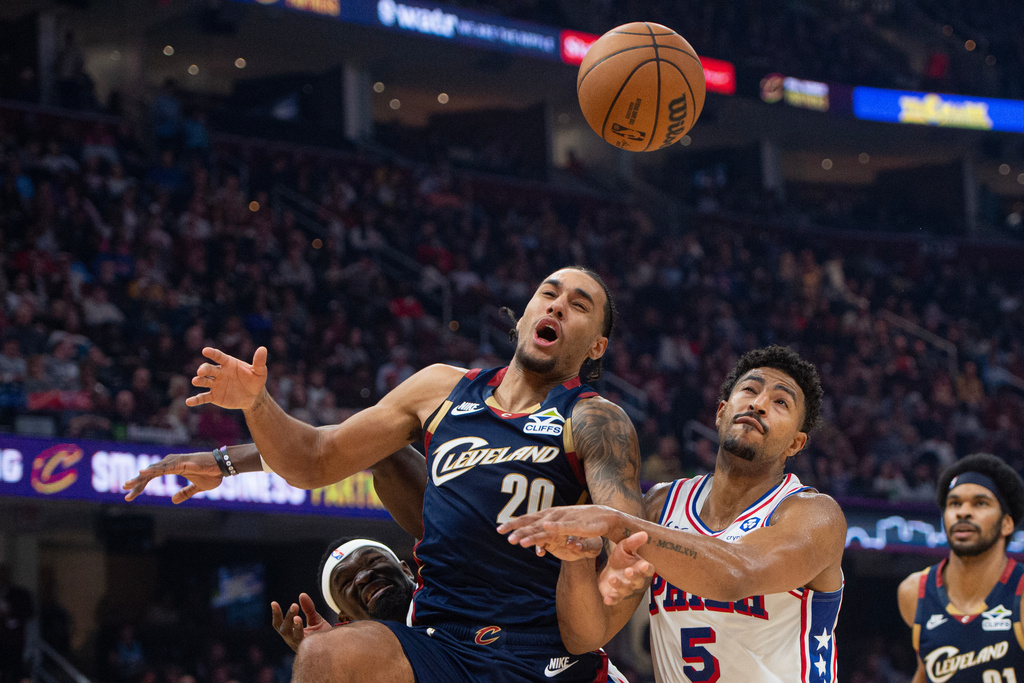Cleveland Cavaliers' Jaylon Tyson (20) and Philadelphia 76ers' Quentin Grimes (5) go for the ball during the first half of an NBA basketball game in Cleveland, Wednesday, Nov. 5, 2025. (AP Photo/Phil Long)