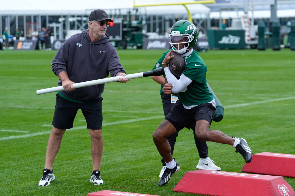 New York Jets' offensive coordinator Frank Reich, left, and Garrett Wilson participate in a drill during practice at the team’s NFL football training camp in Florham Park, N.J., Thursday, July 30, 2026. (AP Photo/Seth Wenig)