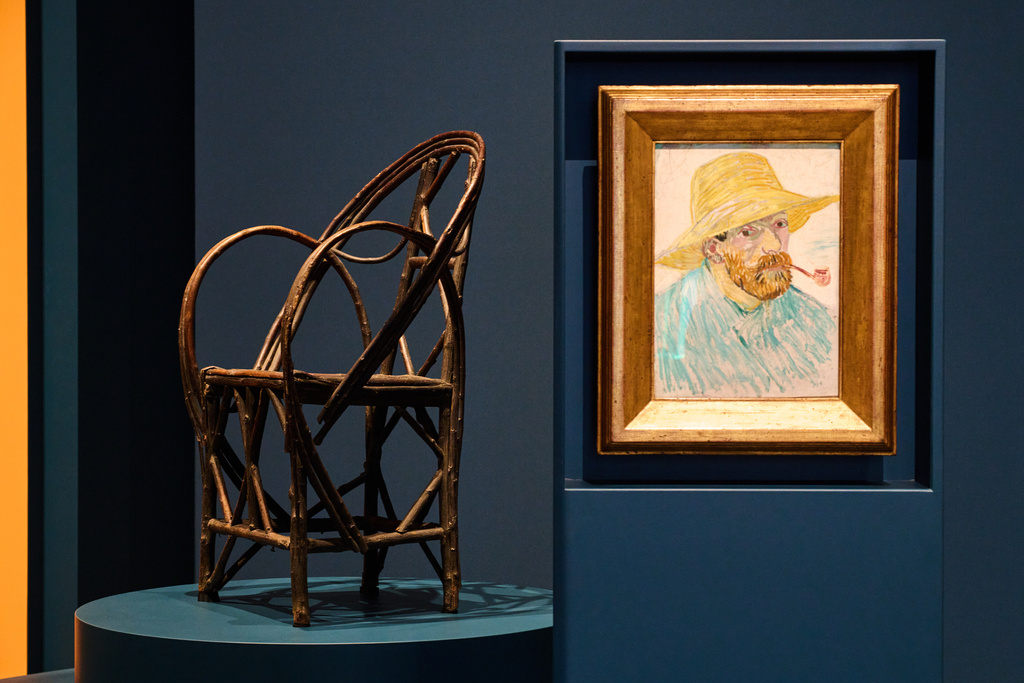 The chair in which bearded postman Joseph Roulin sat when he was portrayed by Vincent Van Gogh is displayed next to a self portrait of Vincent van Gogh at the Van Gogh Museum in Amsterdam, Netherlands, Wednesday, Oct. 1, 2025. (AP Photo/Peter Dejong)