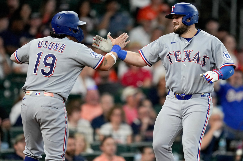 Texas Rangers' Jake Burger, right, celebrates with Alejandro Osuna (19) after hitting a two-run home run against the Houston Astros during the fifth inning of a baseball game, Sunday, May 17, 2026, in Houston. (AP Photo/Eric Christian Smith)