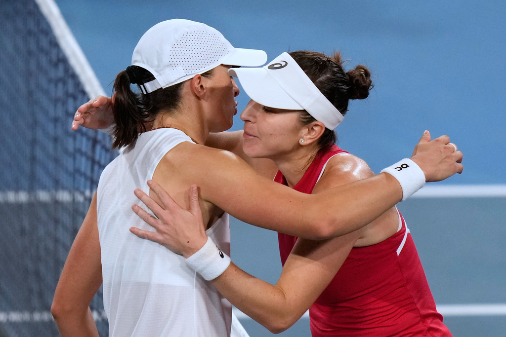 Belinda Bencic of Switzerland, right, and Iga Swiatek of Poland meet at the net after Bencic won their final match at the United Cup tennis tournament in Sydney, Sunday, Jan. 11, 2026. (AP Photo/Rick Rycroft)