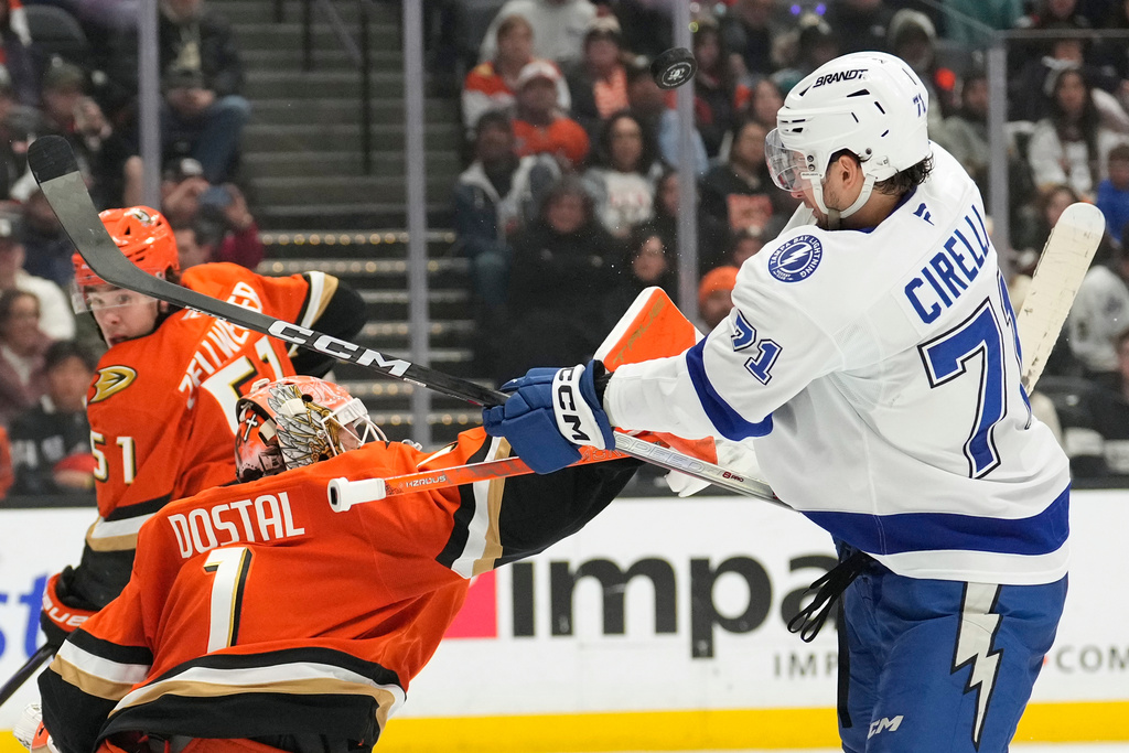 Anaheim Ducks goaltender Lukas Dostal, center, deflects a shot as Tampa Bay Lightning center Anthony Cirelli, right, swings at it during the second period of an NHL hockey game Wednesday, Dec. 31, 2025, in Anaheim, Calif. (AP Photo/Mark J. Terrill)