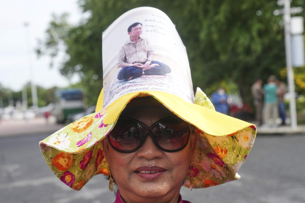 A supporter of Thailand's former Prime Minister Thaksin Shinawatra wears a hat with his image on, outside the Supreme Court in Bangkok, Thailand, Tuesday, Sept. 9, 2025, (AP Photo/Sakchai Lalit)