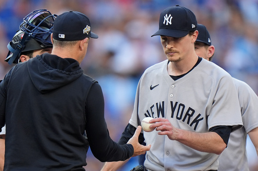 New York Yankees pitcher Max Fried, right, hands the ball to Yankees manager Aaron Boone, left, as he is pulled from the mound during the fourth inning of Game 2 of baseball's American League Division Series against the Toronto Blue Jays in Toronto, Sunday, Oct. 5, 2025. (Frank Gunn/The Canadian Press via AP) New York Yankees pitcher Max Fried, right, hands the ball to Yankees manager Aaron Boone, left, as he is pulled from the mound during the fourth inning of Game 2 of baseball's American League Division Series against the Toronto Blue Jays in Toronto, Sunday, Oct. 5, 2025. (Frank Gunn/The Canadian Press via AP)