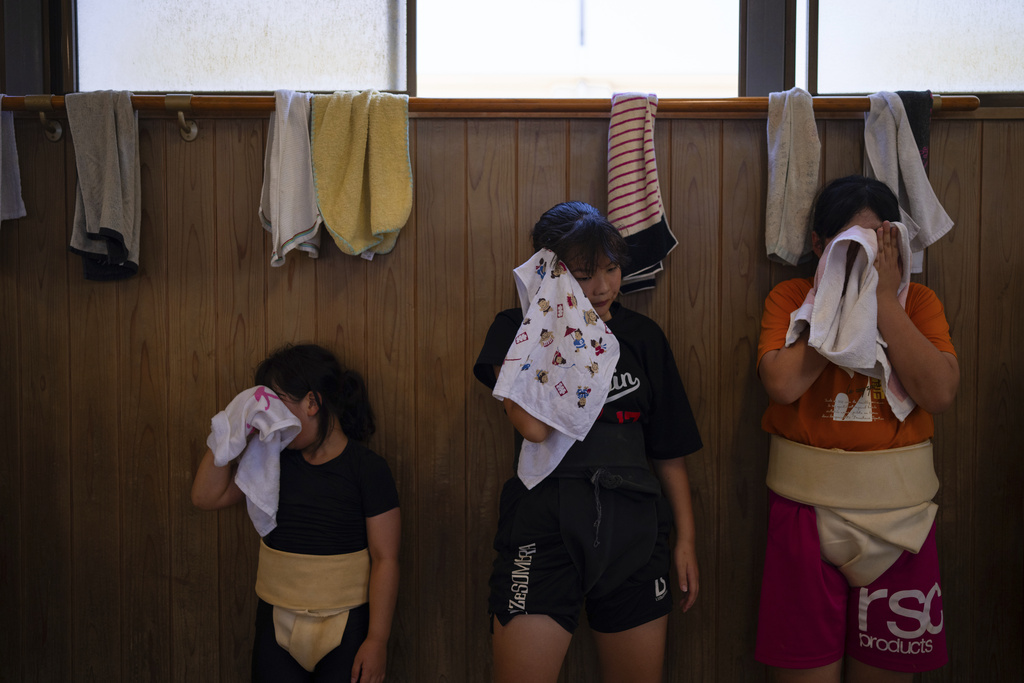 Wrestlers wipe their faces during a practice session at a sumo camp in Tottori Johoku High School in Tottori, Japan, on July 29, 2025. (AP Photo/Louise Delmotte)