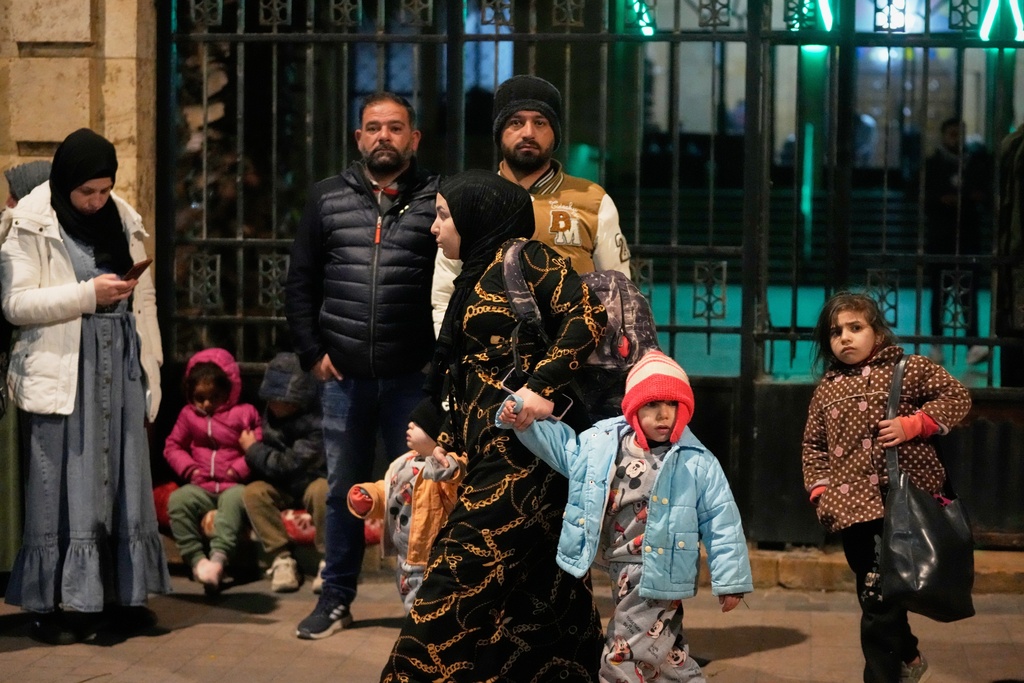 A displaced family fleeing Israeli strikes in southern Lebanon arrives in the southern port city of Sidon, early Monday, March 2, 2026. (AP Photo/Mohammed Zaatari)