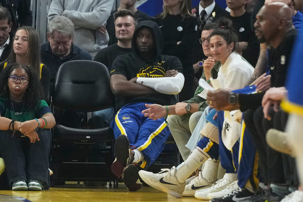 Golden State Warriors forward Jonathan Kuminga, middle, sits near the team bench during the first half of an NBA basketball game against the New York Knicks in San Francisco, Thursday, Jan. 15, 2026. (AP Photo/Jeff Chiu)
