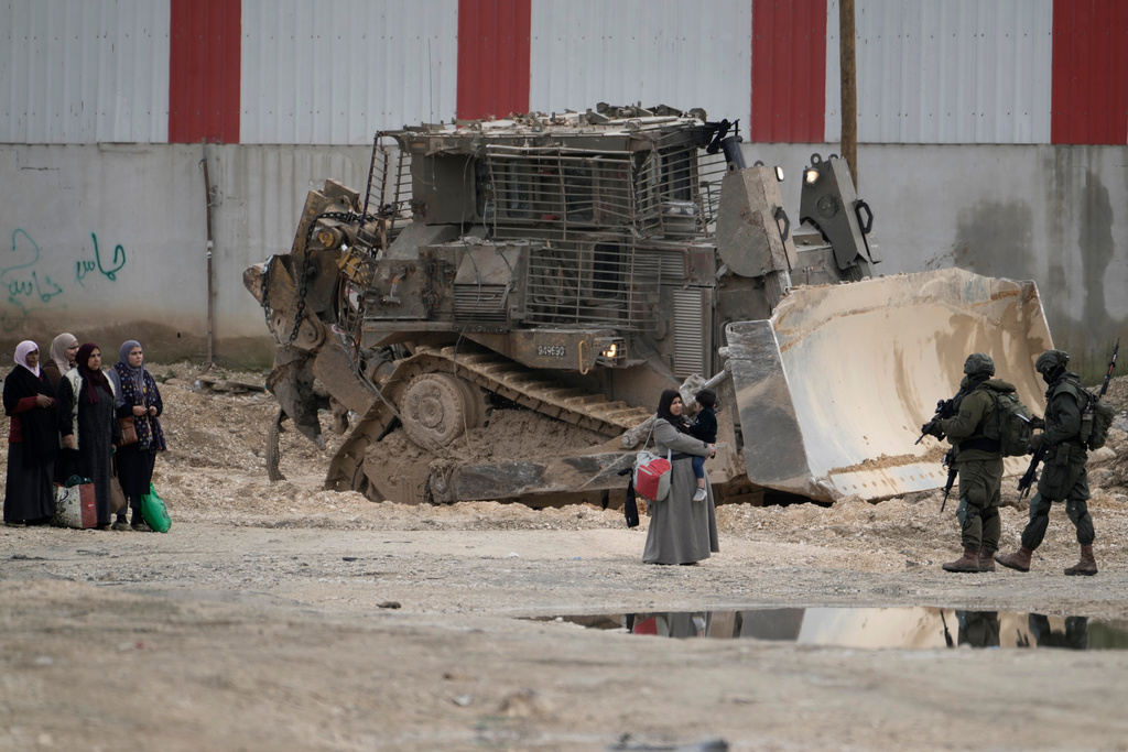 FILE -Israeli soldiers check the identification cards of Palestinians while they evacuate their homes in the West Bank refugee camp of Nur Shams, near Tulkarem, while the Israeli military operation continues in the area on, Feb. 11, 2025. (AP Photo/Majdi Mohammed, File)