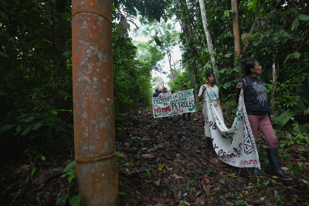 FILE - A group of Indigenous women from across Ecuador's Amazon walk near a support beam for an oil pipeline as they travel through the region on what activists call a toxitour visiting oil fields in Sucumbios, Ecuador, Friday, March 6, 2026. (AP Photo/Dolores Ochoa, File)