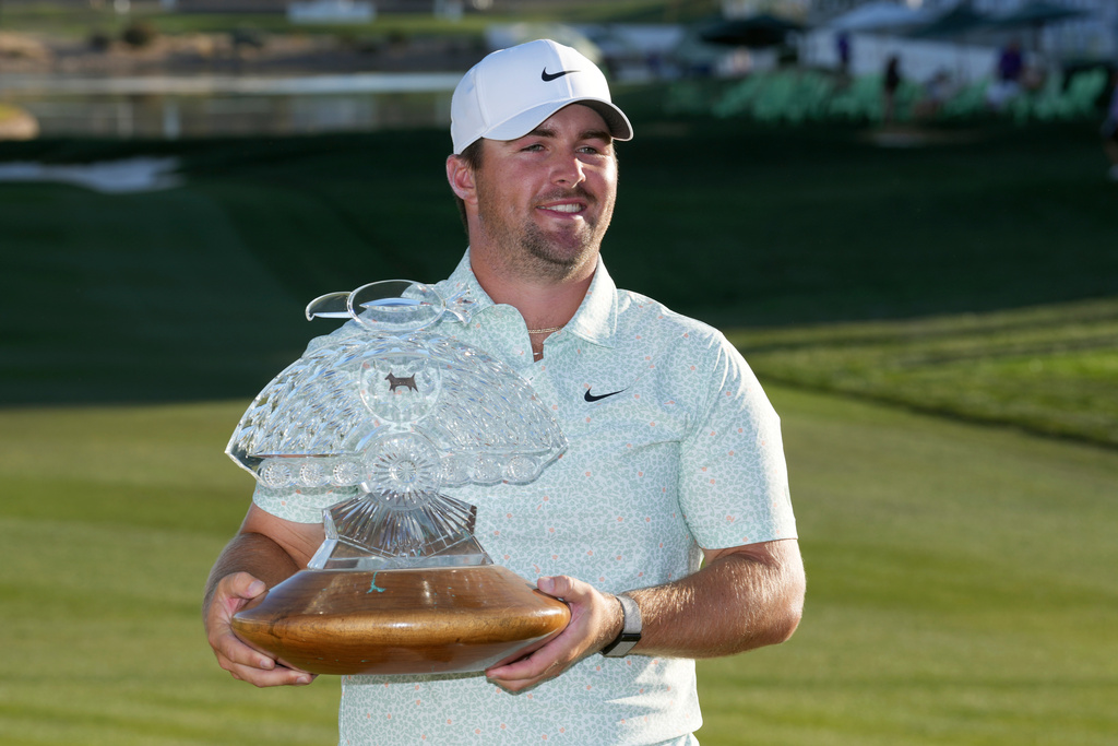 Chris Gotterup smiles as he holds up the winner's trophy after defeating Hideki Matsuyama in a one hole playoff the Phoenix Open golf tournament Sunday, Feb. 8, 2026, in Scottsdale, Ariz. (AP Photo/Ross D. Franklin)