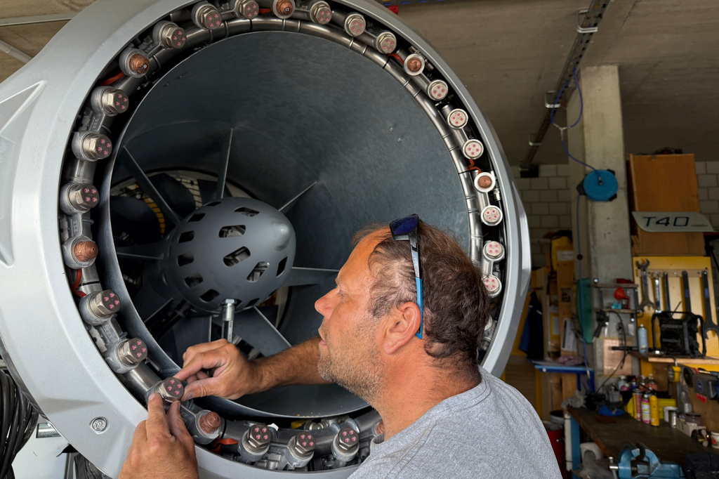 Juerg Klopfenstein, responsible for snowmaking operations at Adelboden-Lenk, inspects a stored snow cannon at a facility near Adelboden, Switzerland, Monday, Aug. 3, 2026. (AP Photo/Hernan Munoz)