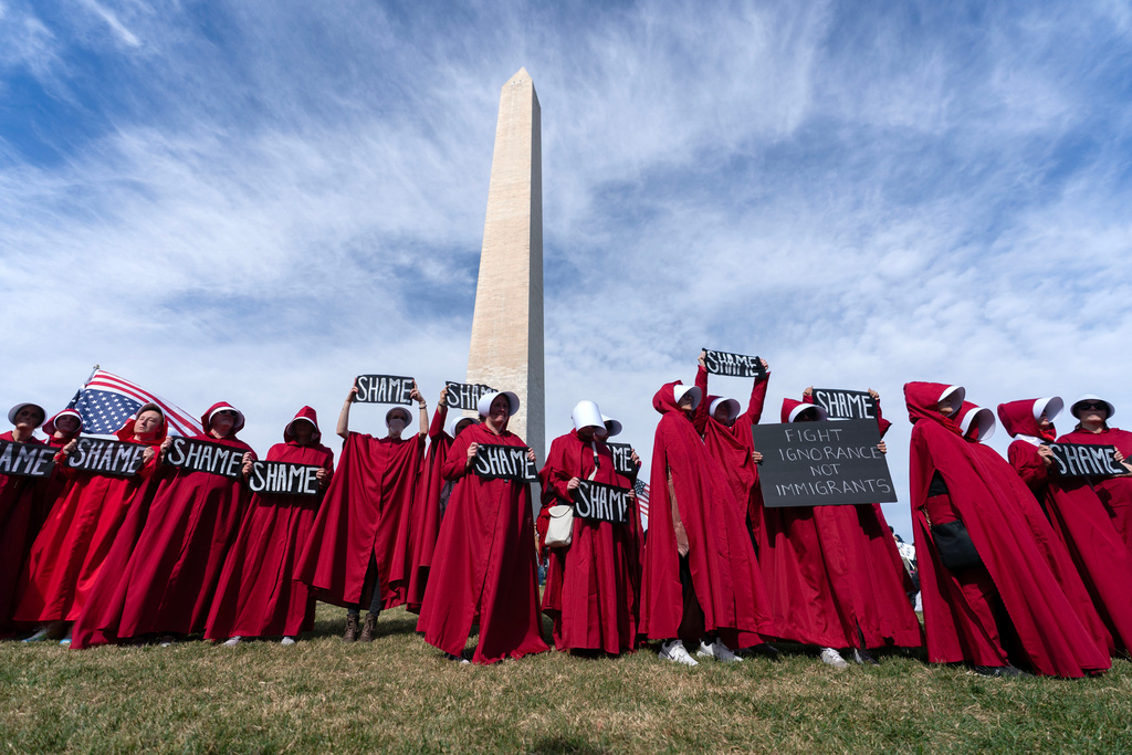 Demonstrators dressed as the tv series The Handmaid's Tale protest at the Washington Monument during Trump Most Go Now rally at the National Mall in Washington, Wednesday, Nov. 5, 2025. (AP Photo/Jose Luis Magana)