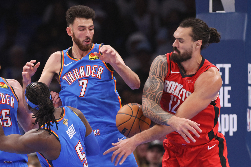Houston Rockets center Steven Adams, right, tries to grab the ball next to Oklahoma City Thunder center Chet Holmgren (7) and guard Luguentz Dort (5) during the first half of an NBA basketball game Tuesday, Oct. 21, 2025, in Oklahoma City. (AP Photo/Nate Billings)