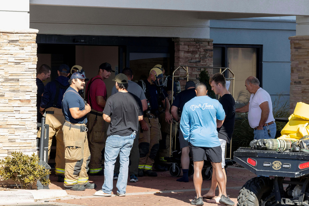 Fire crews bring down guest belongings from their hotel room at the Holiday Inn Express after the evacuation and shelter in place was lifted after a tanker truck had an ammonia gas leak in Weatherford, Okla. on Thursday, Nov. 13, 2025. (AP Photo/Alonzo Adams)