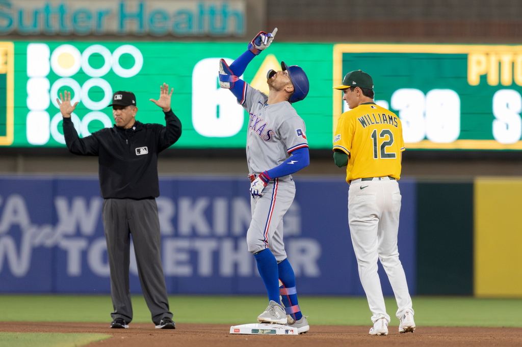 Texas Rangers' Brandon Nimmo, center, celebrates a double during the sixth inning of a baseball game against the Athletics Saturday, Aug. 15, 2026, in West Sacramento, Calif. (AP Photo/Sara Nevis)