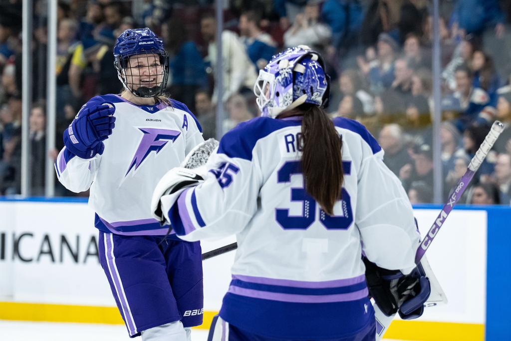 Minnesota Frost's Lee Stecklein, left, celebrates with goaltender Maddie Rooney (35) after defeating the Vancouver Goldeneyes in a PWHL hockey game in Vancouver, British Columbia, Saturday, March 21, 2026. (Ethan Cairns/The Canadian Press via AP)