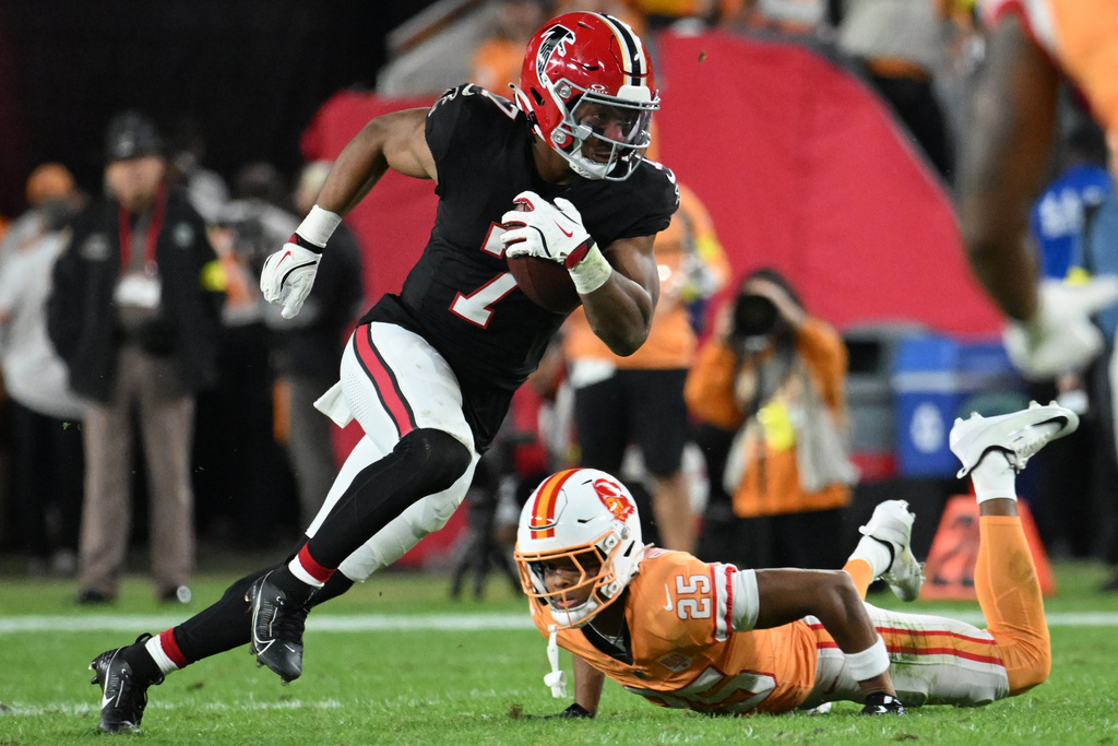 Atlanta Falcons running back Bijan Robinson (7) runs against Tampa Bay Buccaneers cornerback Jacob Parrish (25) during the first half of an NFL football game, Thursday, Dec. 11, 2025, in Tampa, Fla. (AP Photo/Jason Behnken)