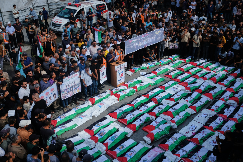 Mourners gather around the flag-draped bodies of Palestinians killed in Israeli strikes during the war with Hamas, whose remains were recently recovered from the rubble, in Gaza City, Sunday, Sept. 6, 2026. (AP Photo/Jehad Alshrafi)