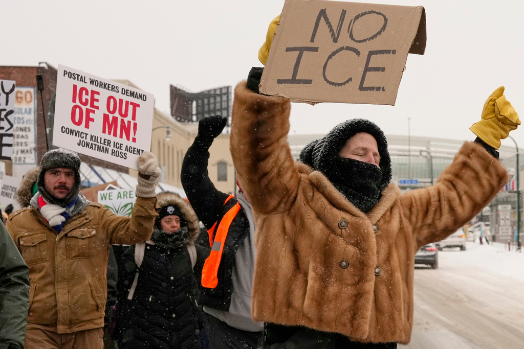 People gather near the post office during a protest, Sunday, Jan. 18, 2026, in Minneapolis. (AP Photo/Yuki Iwamura)