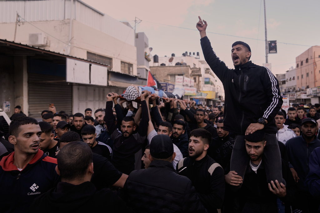 Mourners carry the body of the Palestinian Hassan Ahmed Jamil Moussa,19, who, according to health authorities, was killed during an Israeli raid last night, during his funeral in the Askar camp near the West Bank city of Nablus, Sunday, Nov. 16, 2025. (AP Photo/Majdi Mohammed)
