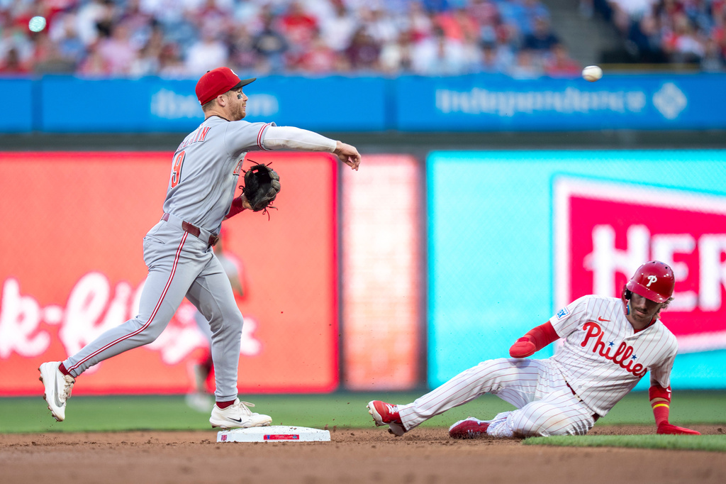 Cincinnati Reds second baseman Matt McLain, left, turns the double play as he gets a force out against Philadelphia Phillies' Bryson Stott, right, during the second inning of a baseball game, Tuesday, May 19, 2026, in Philadelphia. (AP Photo/Chris Szagola)
