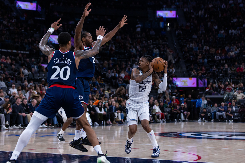 Memphis Grizzlies guard Ja Morant (12) is defended by Los Angeles Clippers players during the first half of an NBA basketball game Monday, Dec. 15, 2025, in Inglewood, Calif. (AP Photo/Ethan Swope)
