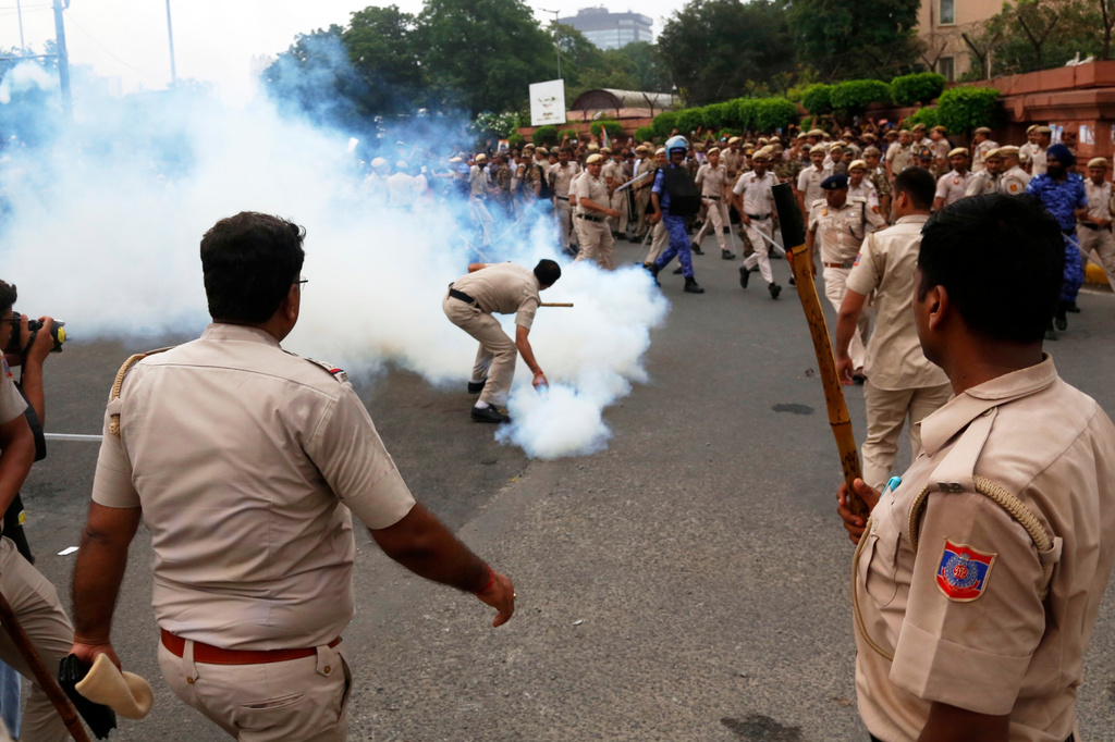 Security officers use tear gas shell to disperse supporters of the Cockroach Janta Party as they attempt to march to India's Parliament, demanding the resignation of the education minister, in New Delhi, Monday, July 20, 2026. (AP Photo/Shekhar Yadav)