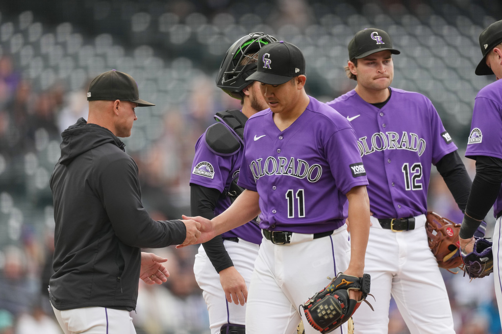 Colorado Rockies manager Warren Schaeffer, left, takes the ball from starting pitcher Tomoyuki Sugano (110 who is pulled from the mound after getting New York Mets' Bo Bichette to ground out in the sixth inning of a baseball game Monday, May 4, 2026, in Denver. (AP Photo/David Zalubowski)