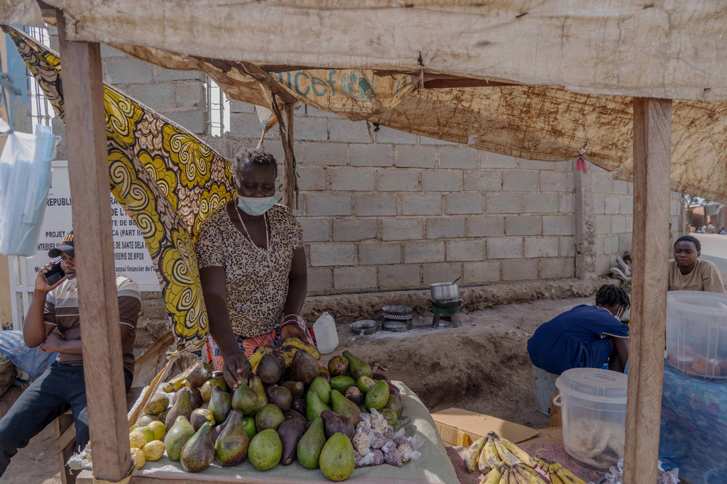 A woman wearing a protective mask sells fruit from a roadside stall in Bunia, Congo, Sunday, May 17, 2026. (AP Photo/Dirole Lotsima Dieudonne)