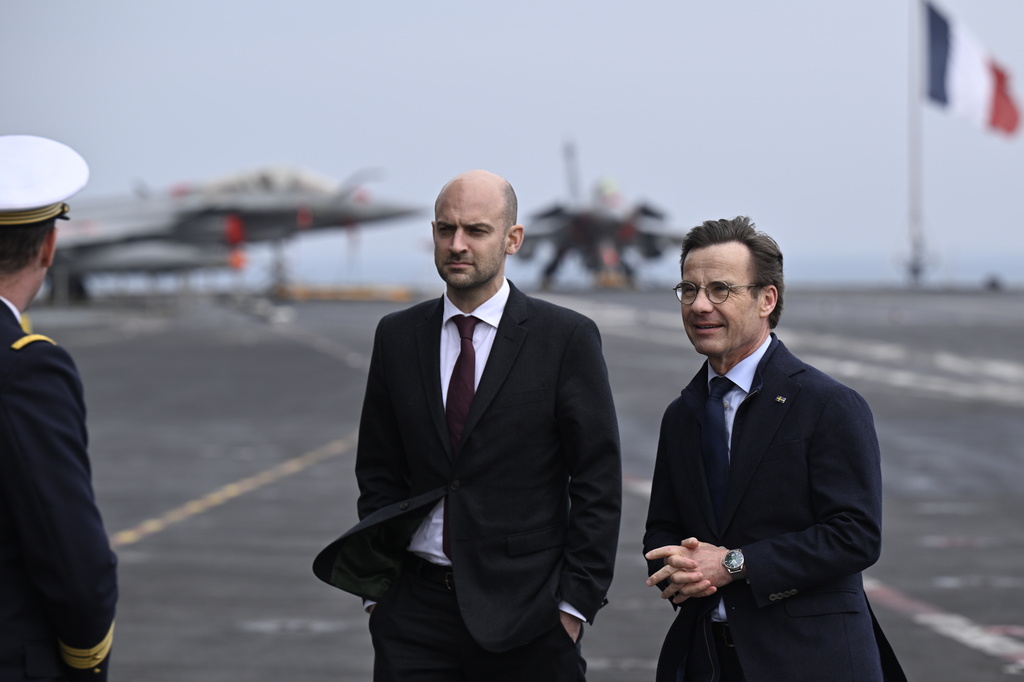French Foreign Minister Jean-Noel Barrot and Swedish Prime Minister Ulf Kristersson, right, meet before the bilateral meeting on the French aircraft carrier Charles De Gaulle (R91) berthed at the North Port in Malmo, Sweden, Friday, Feb. 27, 2026. (Johan Nilsson/TT News Agency via AP)