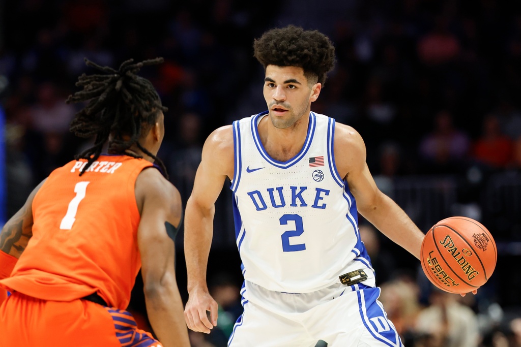 Duke guard Cayden Boozer (2) brings the ball upcourt against Clemson guard Jestin Porter (1) during the first half of an NCAA college basketball game in the semifinals of the Atlantic Coast Conference tournament in Charlotte, N.C., Friday, March 13, 2026. (AP Photo/Nell Redmond)