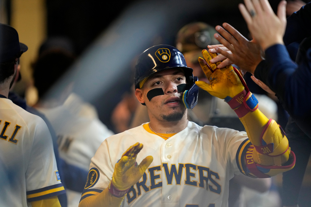 Milwaukee Brewers' William Contreras high-fives teammates after hitting a two-run home run in the third inning of a baseball game against the Arizona Diamondbacks, Thursday, April 30, 2026, in Milwaukee. (AP Photo/Kayla Wolf)