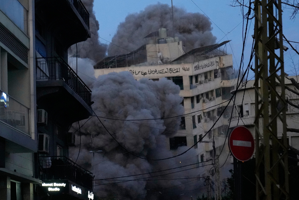 A building collapses as smoke rises following an Israeli strike in central Beirut, Lebanon, Wednesday, March 18, 2026. (AP Photo/Hussein Malla)