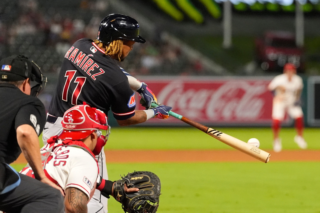 Cleveland Guardians' José Ramírez, right, hits an RBI double as Los Angeles Angels catcher Moisés Ballesteros, center, and home plate umpire Doug Eddings watch during the 10th inning of a baseball game Tuesday, Aug. 25, 2026, in Anaheim, Calif. (AP Photo/Mark J. Terrill)