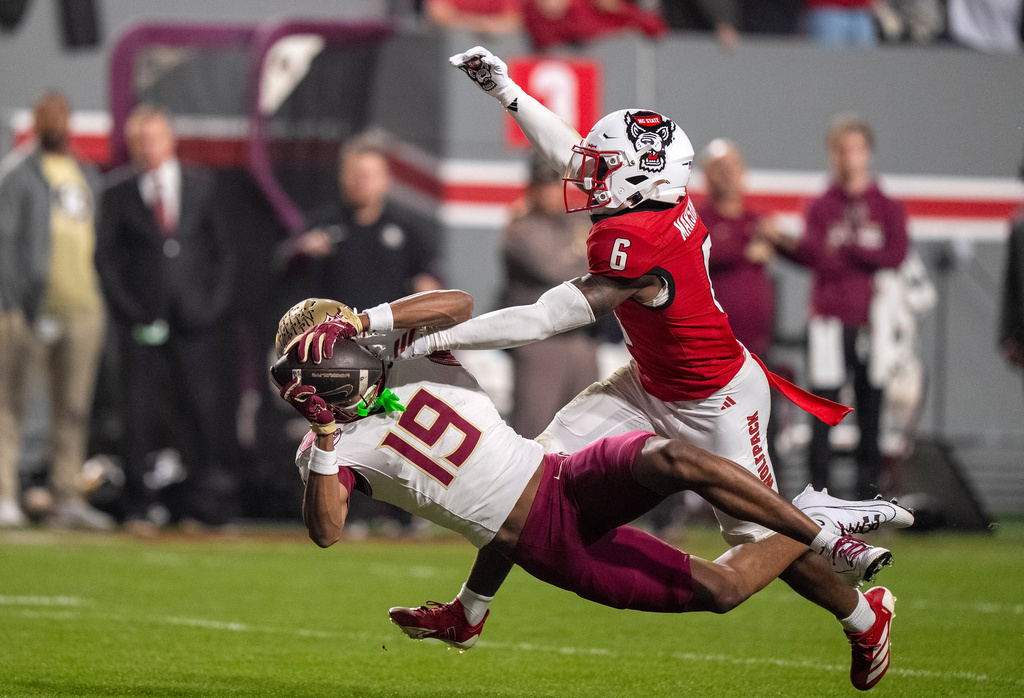 Florida State wide receiver Jayvan Boggs (15) catches a pass over North Carolina State defensive back Devon Marshall (6) during the first half of an NCAA college football game, Friday, Nov. 21, 2025, in Raleigh, N.C. (AP Photo/David Yeazell)