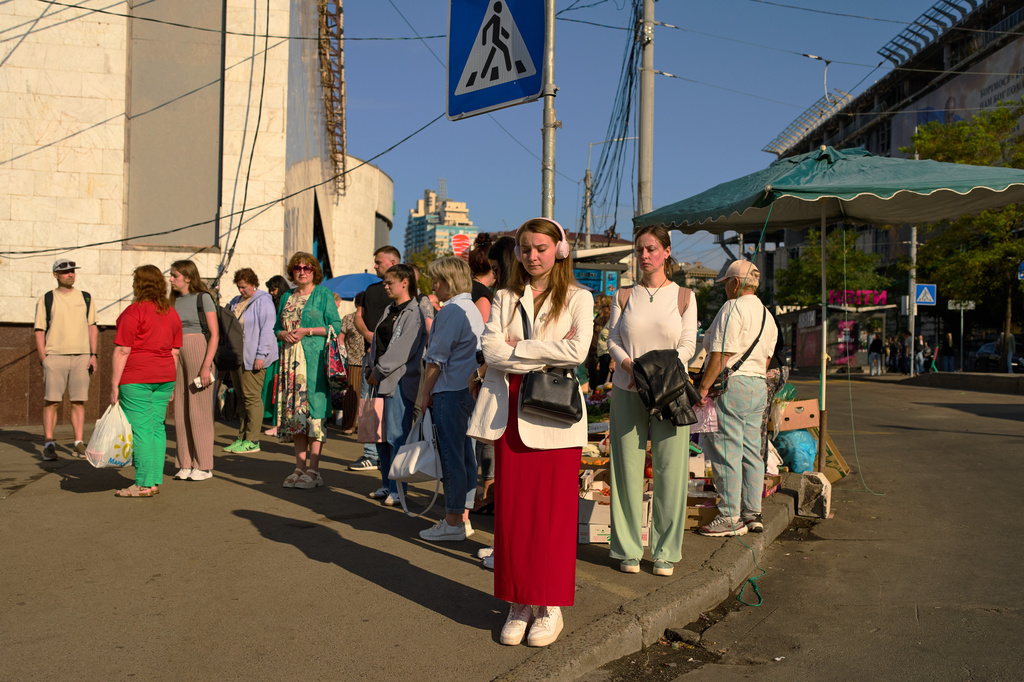 People observe a daily nationwide minute of silence in memory of soldiers killed in the war with Russia, in the Lukianivska neighborhood of Kyiv, Ukraine, Thursday, Aug. 27, 2026. (AP Photo/Francisco Seco)