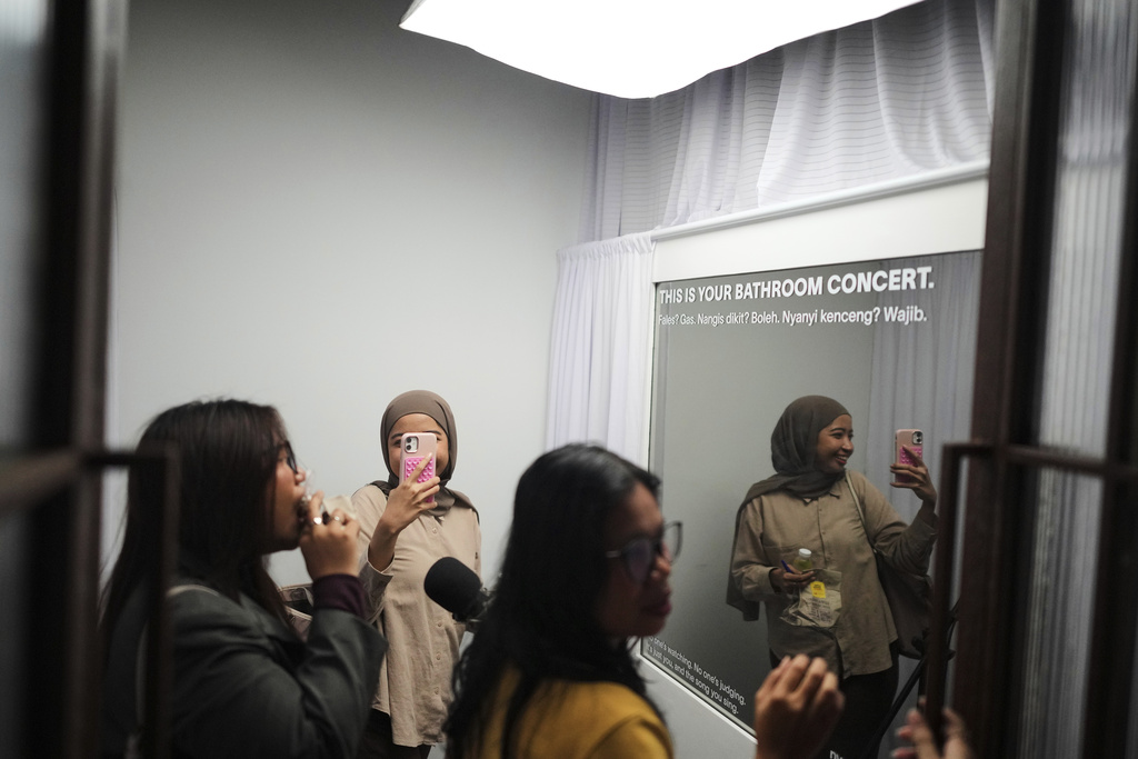 Participants enter a "No Judgement Room" where they sing and express themselves, during a gathering of "Nyanyi Bareng Jakarta" or "Singing Together Jakarta" community in Jakarta, Indonesia, Saturday, July 19, 2025. (AP Photo/Dita Alangkara)