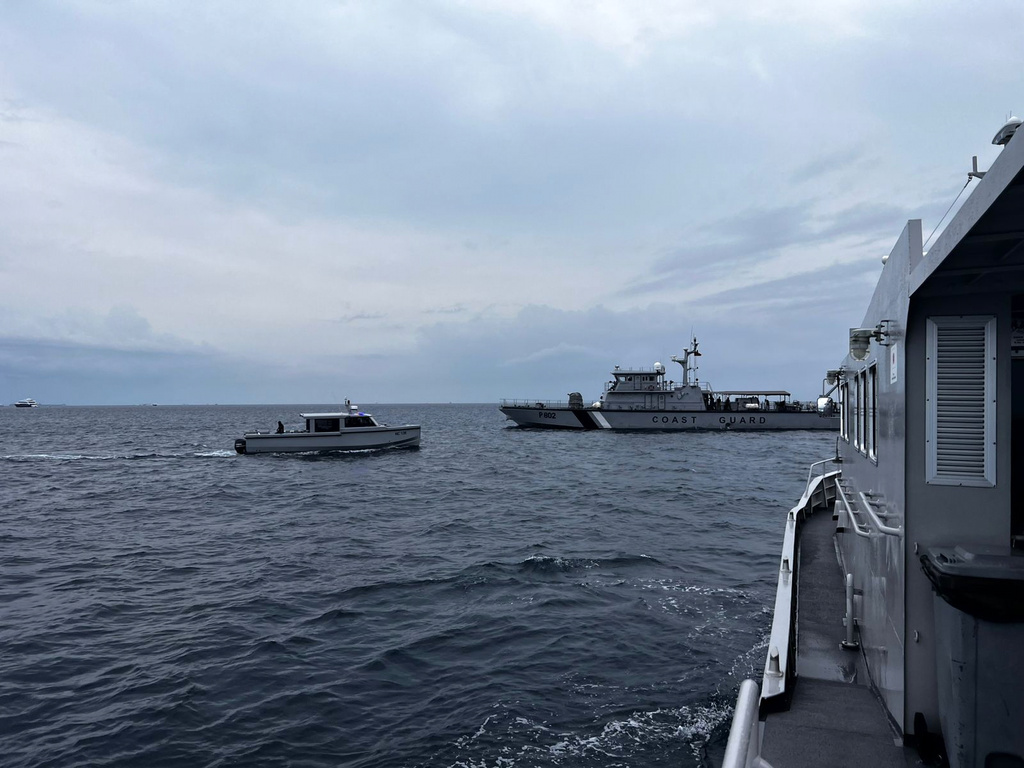 This image released by the Maldives President's Media Division, shows a coast guard boat and other vessels deployed to search for the four missing Italian divers near Alimathaa Island, Vaavu Atoll, Maldives, Saturday, May 15, 2026. (Maldives President's Media Division via AP)