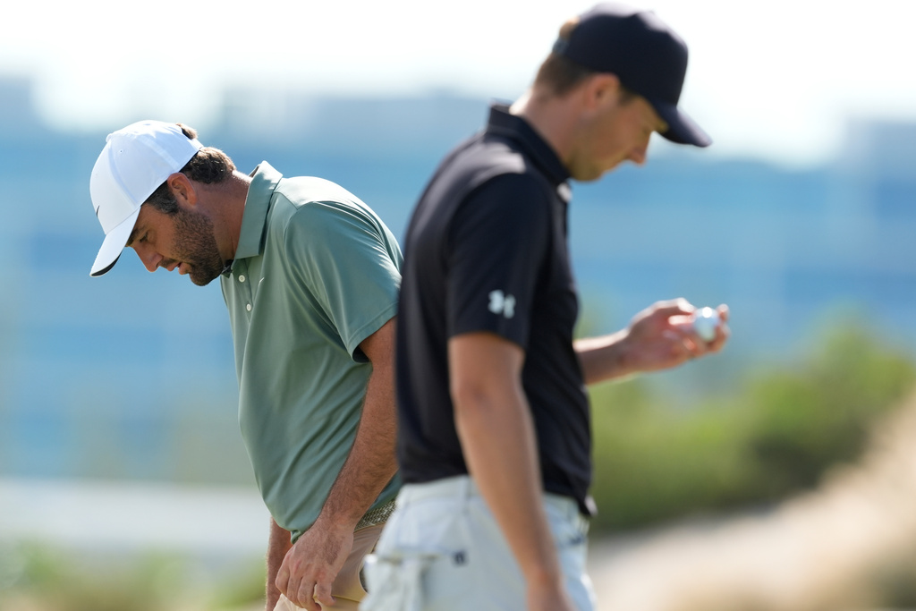 Scottie Scheffler, left, walks near Jordan Spieth, both of the United States, on the third green during the first round of the Hero World Challenge PGA Tour at the Albany Golf Club, in New Providence, Bahamas, Thursday, Dec. 4, 2025. (AP Photo/Fernando Llano)