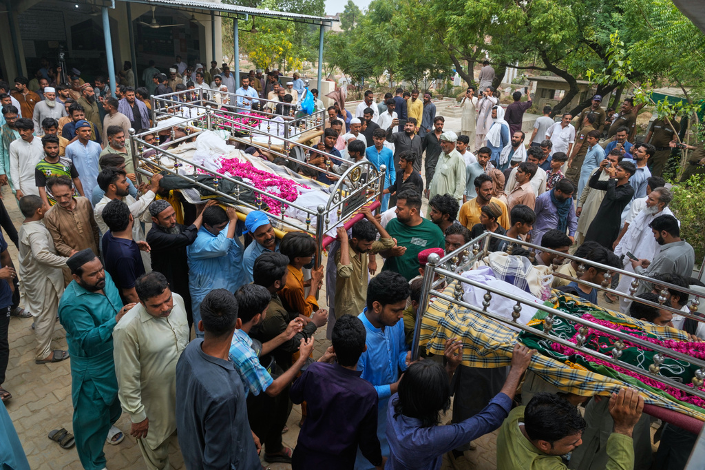 People carry the bodies of children, who were killed in the roof collapse at a tutoring center that was under construction after a funeral prayer, on the outskirts of Lahore, Pakistan, Wednesday, July 1, 2026. (AP Photo/K.M. Chaudary)