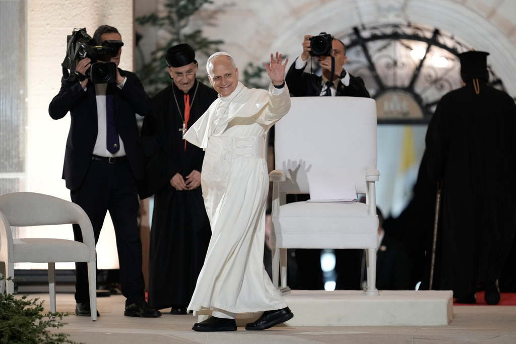Pope Leo XIV greets the crowd as he arrives surrounded by security for a meeting with youths in Bkerki, the seat of the Maronite Church, in Lebanon, Monday, Dec. 1, 2025. (AP Photo/Bilal Hussein)