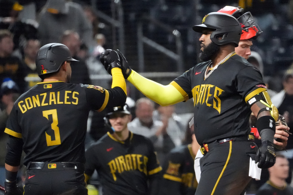 Pittsburgh Pirates' Marcell Ozuna celebrates with Nick Gonzales (3) on his way back to the dugout after his two run home run off of Cincinnati Reds pitcher Zach Maxwell in the fifth inning of a baseball game in Pittsburgh, Friday, May 1, 2026. (AP Photo/Tom E. Puskar)